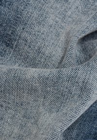Denimstof in lichtblauwe tinten met een gestructureerde afwerking, gekenmerkt door een klassieke twill-weving en subtiele vervaging. Glad en zacht aanvoelend.