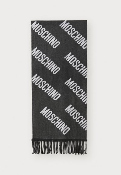 Fekete sál átlós fehér "MOSCHINO" feliratmintával és fekete bojtokkal mindkét végén, fehér háttéren elterítve.