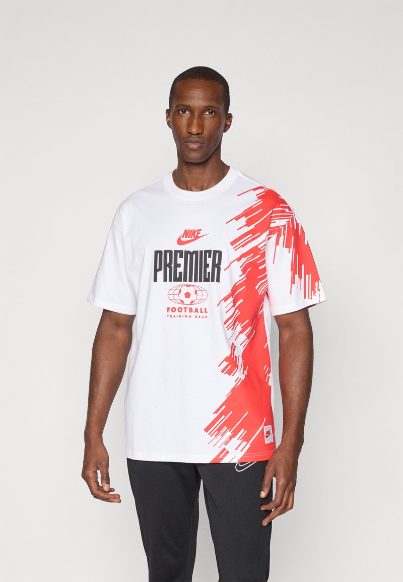 Nike Premier hvid t-shirt med rødt abstrakt design, prydet med et sort grafisk tryk, der siger "FOOTBALL TRAINING GEAR" og logo detalje.