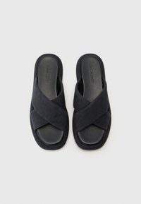 Sorte slip-on sandaler med kryssrem-design. Laget av mykt semsket skinn med teksturert finish og flat gummisåle.