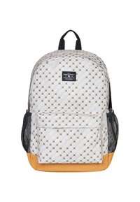 Biały plecak pikowany z złotym geometrycznym wzorem, czarnymi siateczkowymi kieszeniami bocznymi i brązowym dnem; posiada uchwyt na górze oraz przednią kieszeń na zamek.