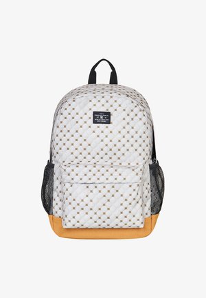 Sac à dos matelassé blanc avec un motif géométrique doré, poches latérales en maille noire et base beige ; dispose d'une poignée supérieure et d'une poche zippée à l'avant.