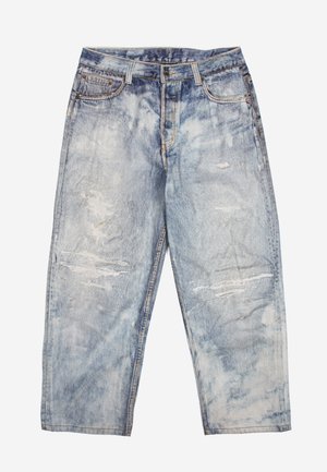 Ανοιχτό μπλε, ψηλόμεσο τζιν με φαρδιά μπατζάκια, με εφέ ται-νταϊ και φθορές στα μπροστινά μπουτάκια.