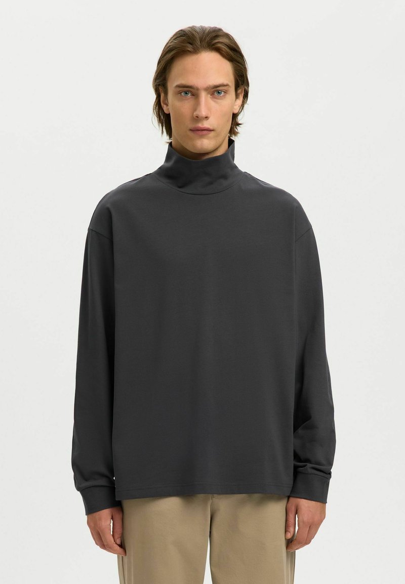 Donkergrijze turtleneck met lange mouwen, gemaakt van gladde stof. Heeft een relaxed fit en verlaagde schouders, met minimale stikseldetails.