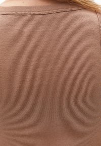 Tessuto a coste marrone, design aderente, texture morbida, con scollatura arrotondata e dettagli di cucitura sottili.