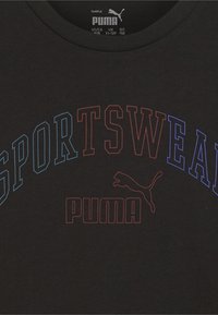 Camiseta de algodón negra con la palabra "SPORTSWEAR" en colores de texto degradado: azul y rojo. Incluye el logo de Puma en una combinación de colores a juego.