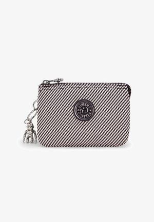 Gestreifte Stofftasche in Schwarz und Weiß mit rundem Logo, Reißverschluss und einem silbernen Anhänger. Glatte Textur, kompakte rechteckige Form.