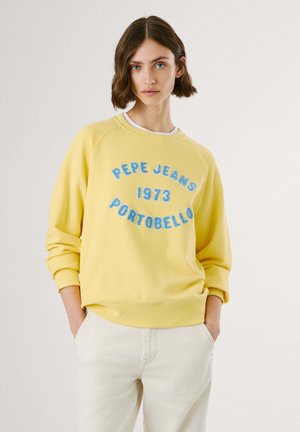 Felpa gialla con la scritta "PEPE JEANS 1973 PORTOBELLO" stampata in blu. Presenta un collo rotondo e polsini a costine, progettata con una vestibilità comoda.