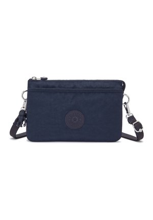 Navy blue crossbody bag made of textured fabric featuring a zip closure, logo patch, and adjustable strap with a detachable keychain charm.