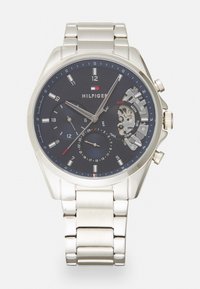 Silver stainless steel watch with a dark blue dial. Features include hour and minute hands, three sub-dials, and a date display.
