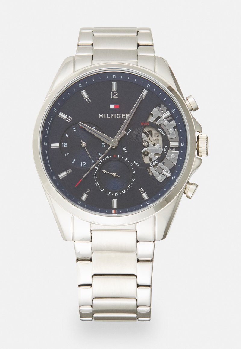 Silver stainless steel watch with a dark blue dial. Features include hour and minute hands, three sub-dials, and a date display.