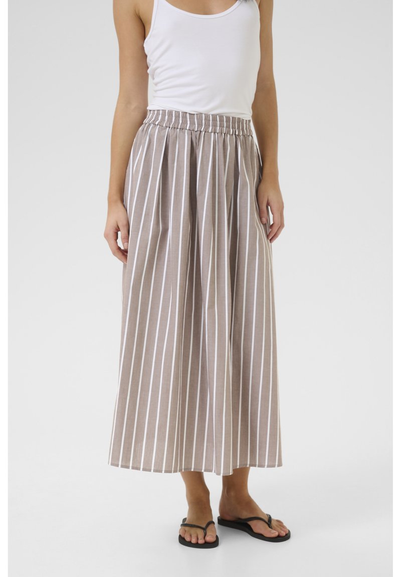 Raikka beige maxi-hame, jossa on valkoisia pystyraitoja, joustava vyötärö ja kevyttä kangasta. Yhdistetty valkoiseen toppiin ja mustiin sandaaleihin.