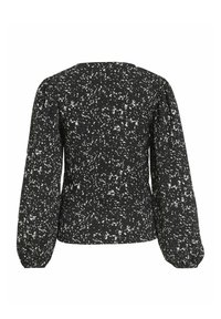 Blusa negra con patrón blanco moteado, mangas abullonadas, escote redondo y una tela texturizada. La vista posterior muestra un corte entallado.