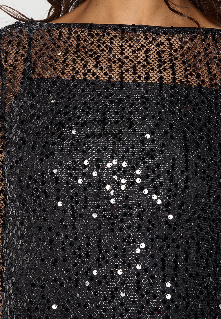 Schwarzes Paillettenoberteil mit einem transparenten metallischen Netzüberzug, weitem Ausschnitt und einer strukturierten Oberfläche, die durch verstreute Pailletten entsteht.