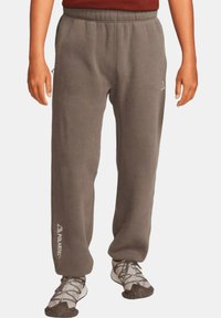 Grå fleecebyxor med elastisk midja och rak benform. Har en vit "Polartec"-logotyp på vänster sida.