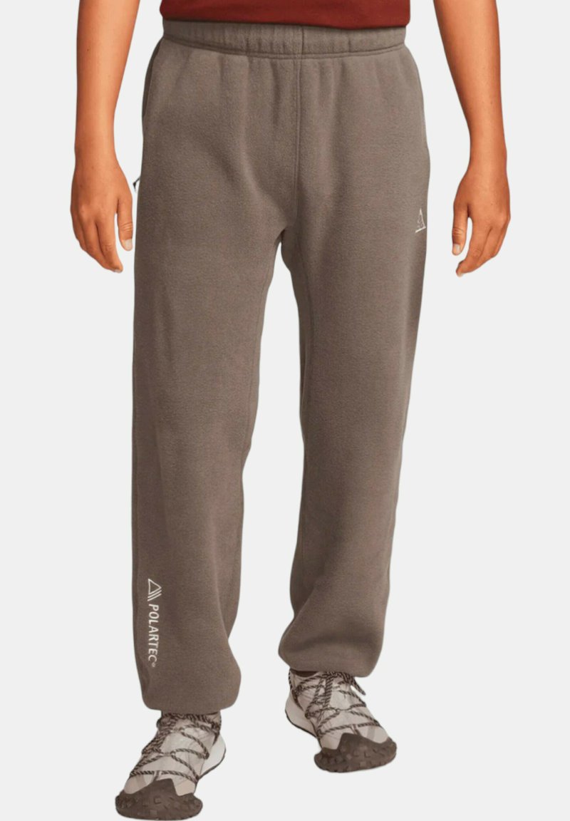 Grå fleecebyxor med elastisk midja och rak benform. Har en vit "Polartec"-logotyp på vänster sida.