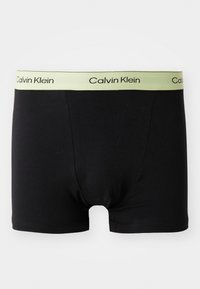 Svarte boksershorts laget av mykt materiale, med en lys grønn elastisk midje med "Calvin Klein"-merke. Flate sømmer og ingen synlige logoer på kroppen.