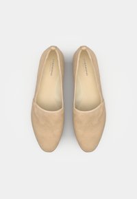 Beige Wildleder Ballerinas mit runder Spitze, glatter Textur und minimalistischem Design. Das Innere ist hell gefärbt und das Markenlogo ist sichtbar.