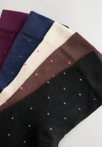 Baumwollsocken in fünf Farben: dunkelrot, marineblau, creme, braun und schwarz, jeweils mit kleinen rosa Punkten und gerippten Bündchen. Weiche Textur und gestricktes Design.