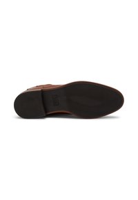 Zapato de cuero marrón con una suela de goma negra texturizada. El diseño presenta una punta redondeada y un acabado liso, con detalles de herrajes mínimos.