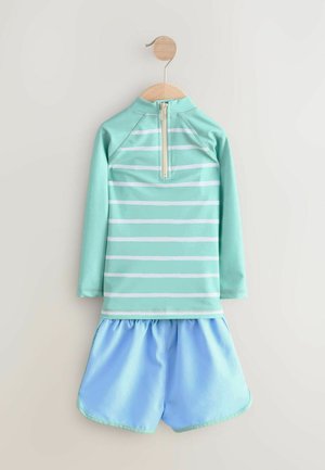 Set da nuoto turchese composto da un top a maniche lunghe con strisce bianche e una cerniera, abbinato a pantaloni corti azzurri. Tessuto morbido, design casual.