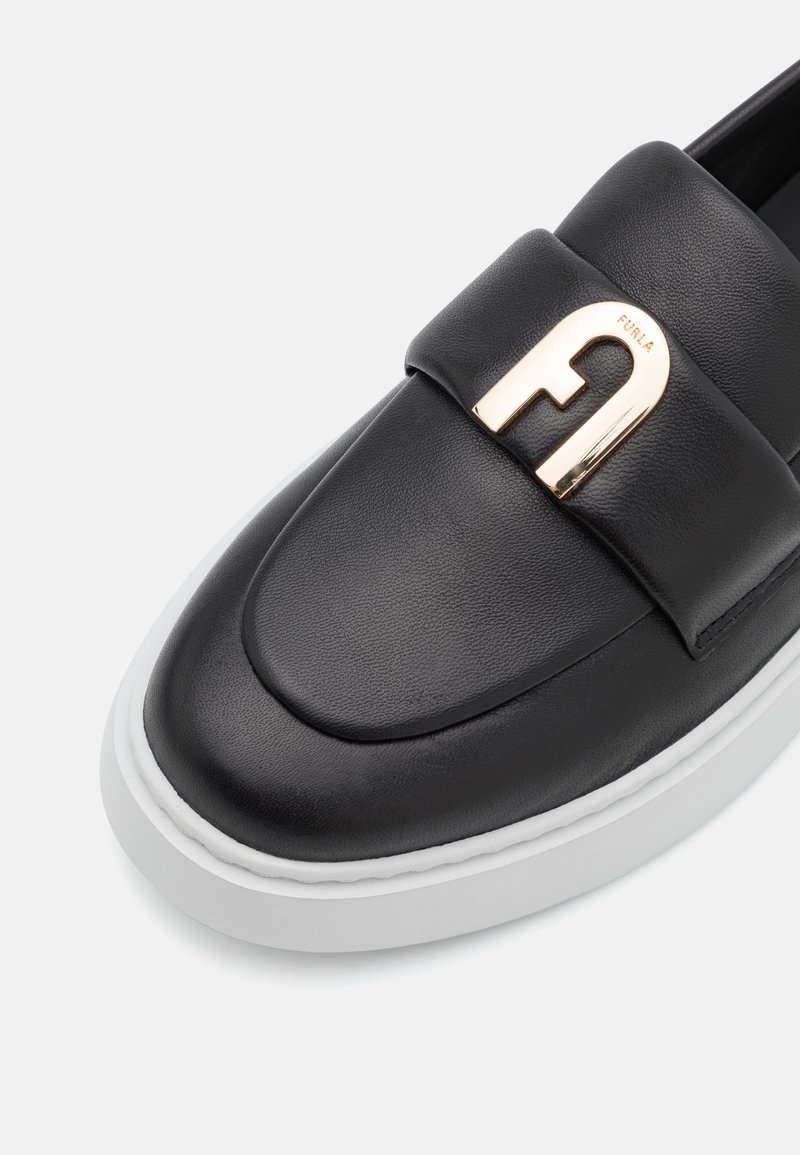 Czarny skórzany but wsuwany z wyściełanym wierzchem, z akcentem w postaci logo Furla w kolorze złotym oraz białą gumową podeszwą. Gładka tekstura, zaokrąglony kształt.