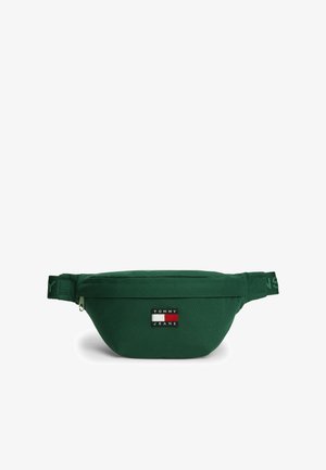 Dunkelgrüne Gürteltasche mit Reißverschluss und Tommy Jeans Logoaufnäher mittig vorne. Verstellbarer Riemen mit gebrandetem Text an den Seiten.