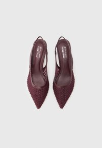 Viininpunaiset vegaaniset slingback-korkokengät terävällä kärjellä, joissa on punottu ritiläkuvio ja massiivinen korko. Sileä sisävuori.