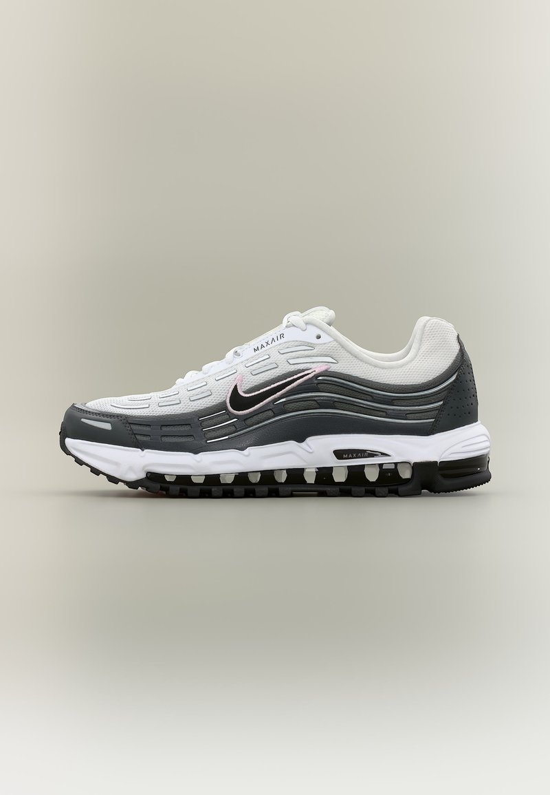 Λευκό και γκρι αθλητικό παπούτσι Nike Max Air με μαύρη σόλα και ορατή αερόσολα κατά μήκος της κάτω ακμής, πλευρά στραμμένη προς τα αριστερά.