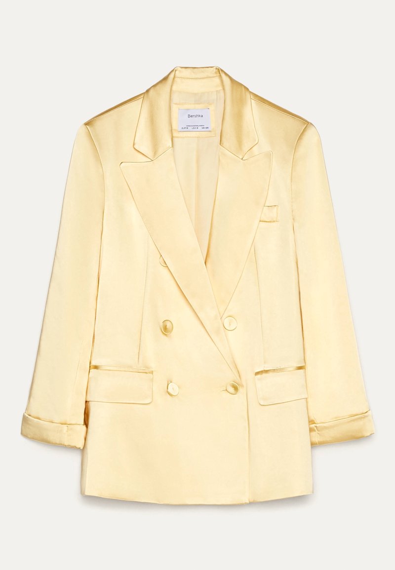 Podwójnie zapięta marynarka w miękkim żółtym satynie z klapami, przednimi kieszeniami i gładką fakturą; z przodu zapięcie na guziki oraz dopasowany fason.