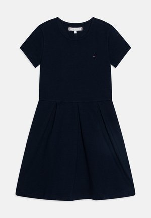 Granatowa sukienka z krótkim rękawem, okrągłym dekoltem, plisowaną spódnicą i małym logo Tommy Hilfiger na piersi.