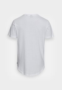 White cotton t-shirt with a round neck, short sleeves, and a curved hem. No visible patterns or decorations. Smooth texture.