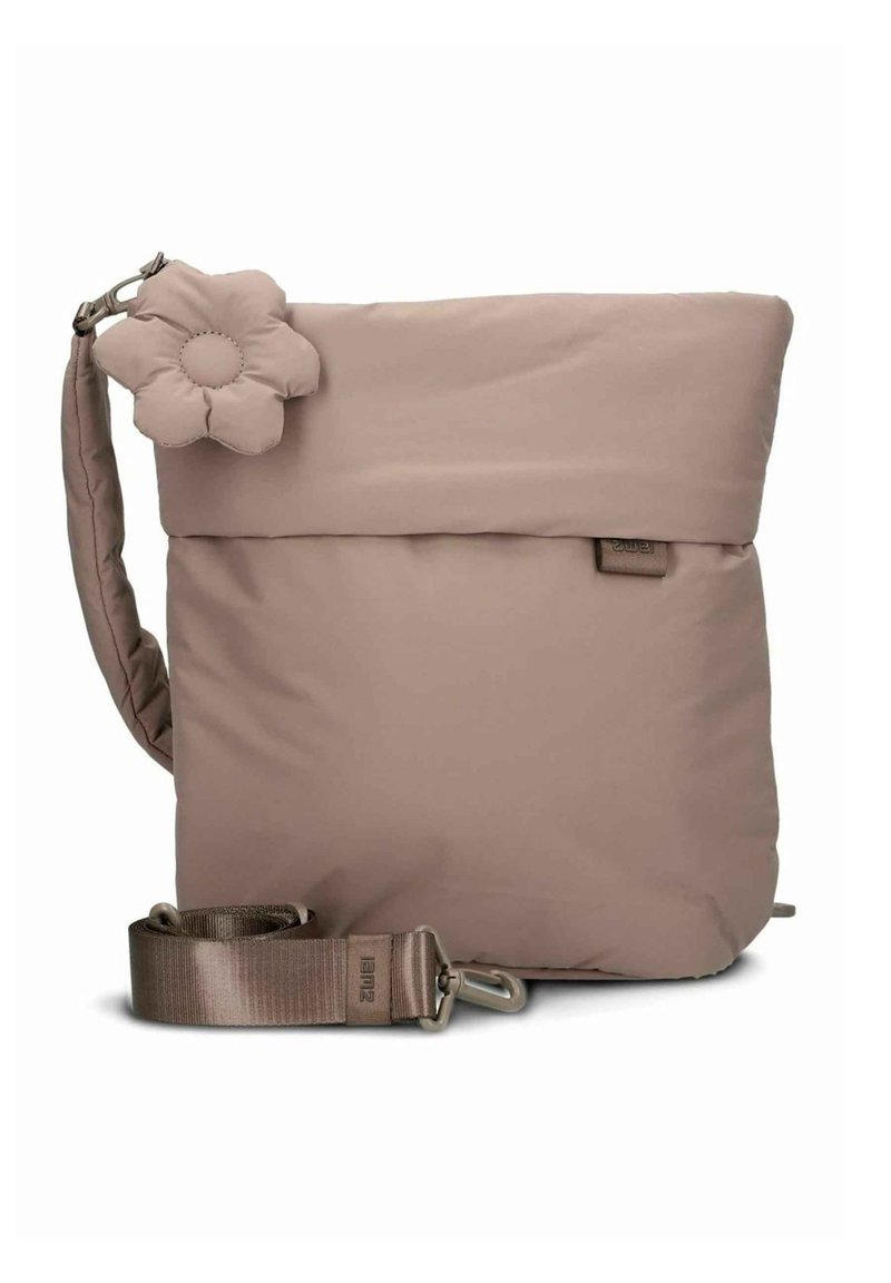 Sac à bandoulière beige matelassé avec rabat, accent en forme de fleur, bandoulière réglable et garniture métallique. Texture lisse et design minimaliste.