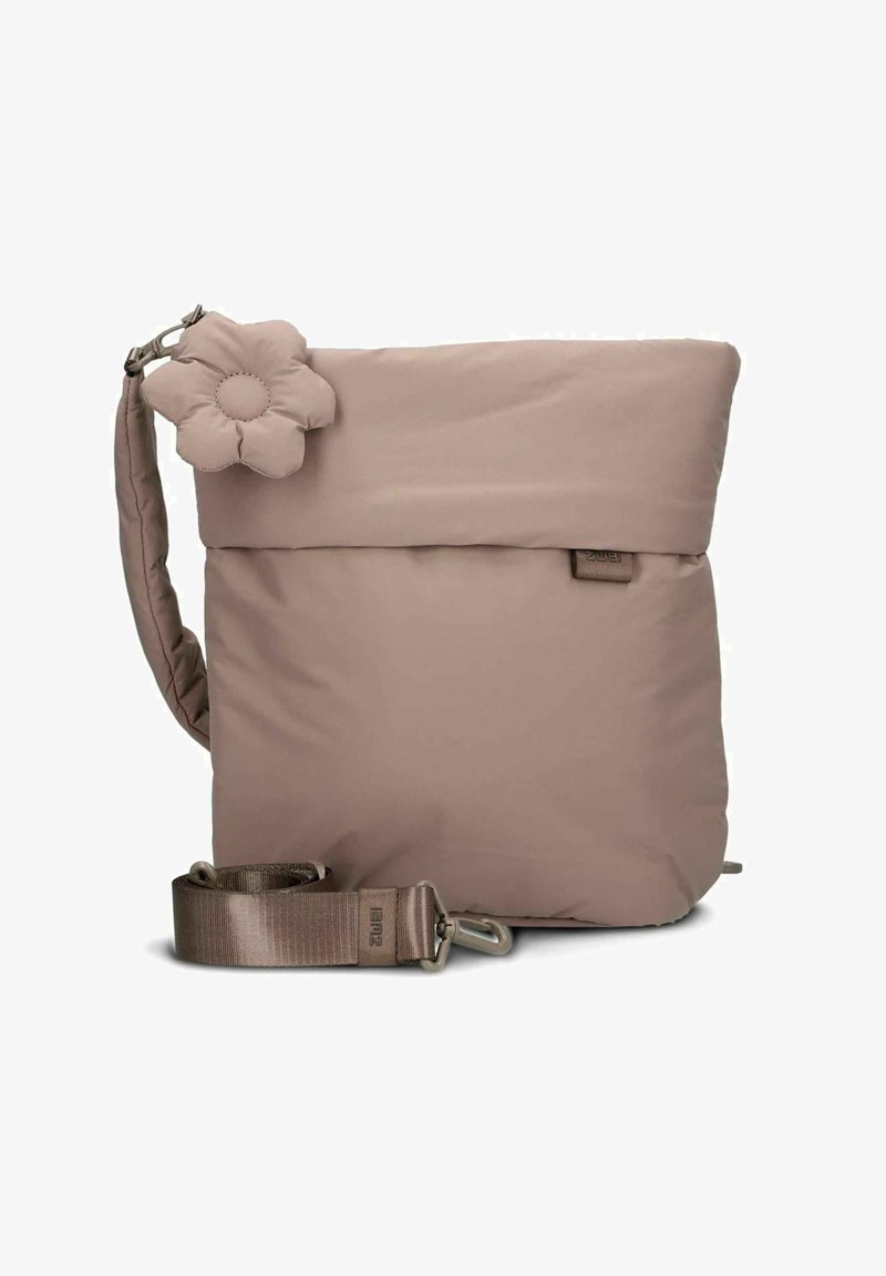 Sac à bandoulière beige matelassé avec rabat, accent en forme de fleur, bandoulière réglable et garniture métallique. Texture lisse et design minimaliste.