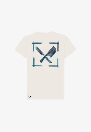 T-shirt blanc avec un graphisme noir et bleu représentant des couteaux de cuisine croisés à l'intérieur d'un cadre carré au dos, et une petite icône assortie près de l'ourlet inférieur.