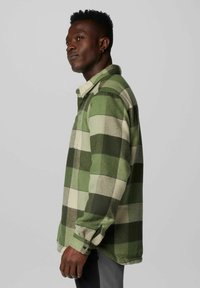 Grüne und cremfarbene karierte Flanell-Hemdjacke mit lockerer Passform, langen Ärmeln und einem Button-Down-Kragen. Weiche Textur und sichtbare Nähdetails.