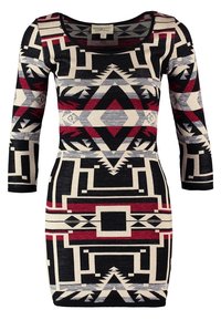 Robe ajustée à manches 3/4 avec des motifs géométriques en noir, rouge, beige et gris, incluant des losanges et des formes angulaires.