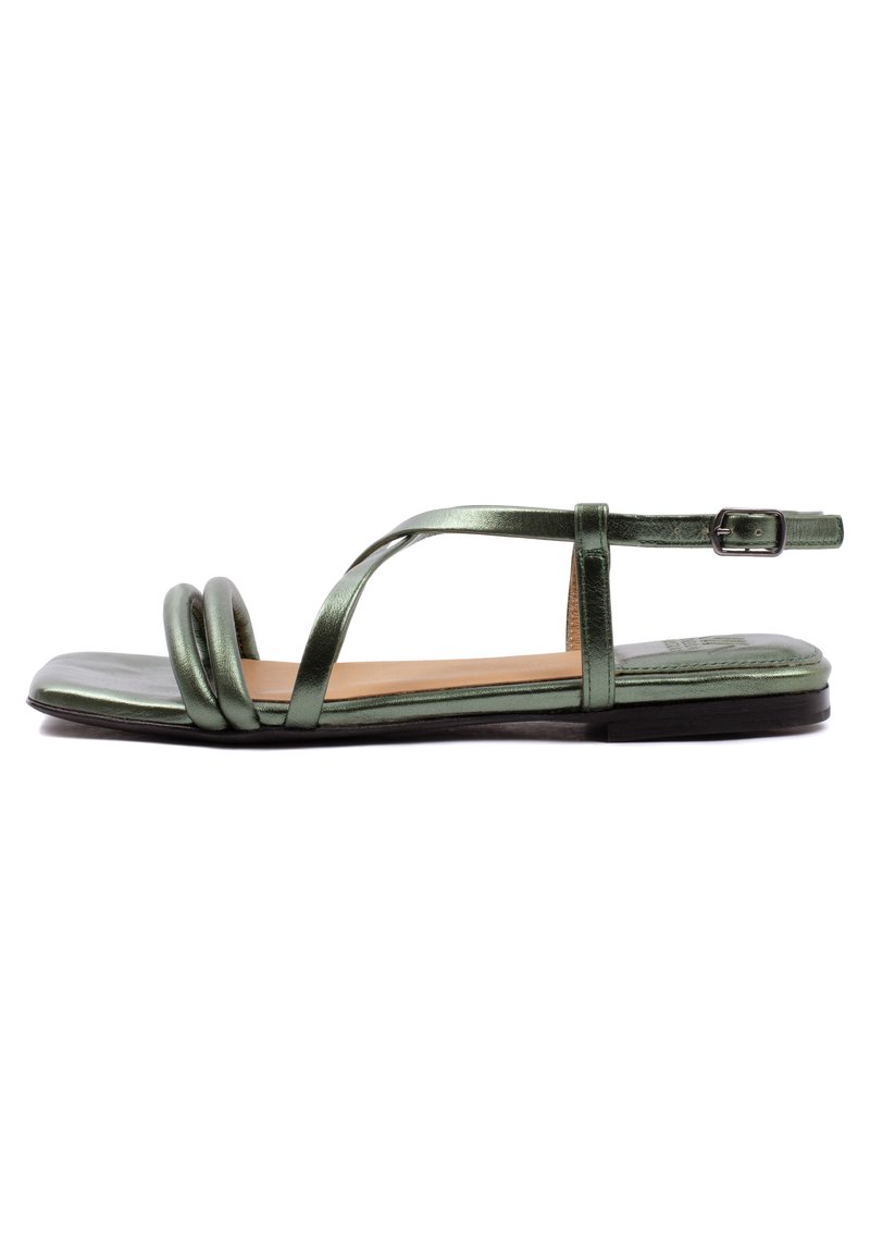 Grüne metallische flache Sandalen mit einer abgerundeten Zehenpartie, die ein Kreuzriemen-Design und zwei gedrehte Riemen vorne haben. Schnallenverschluss am Knöchel.