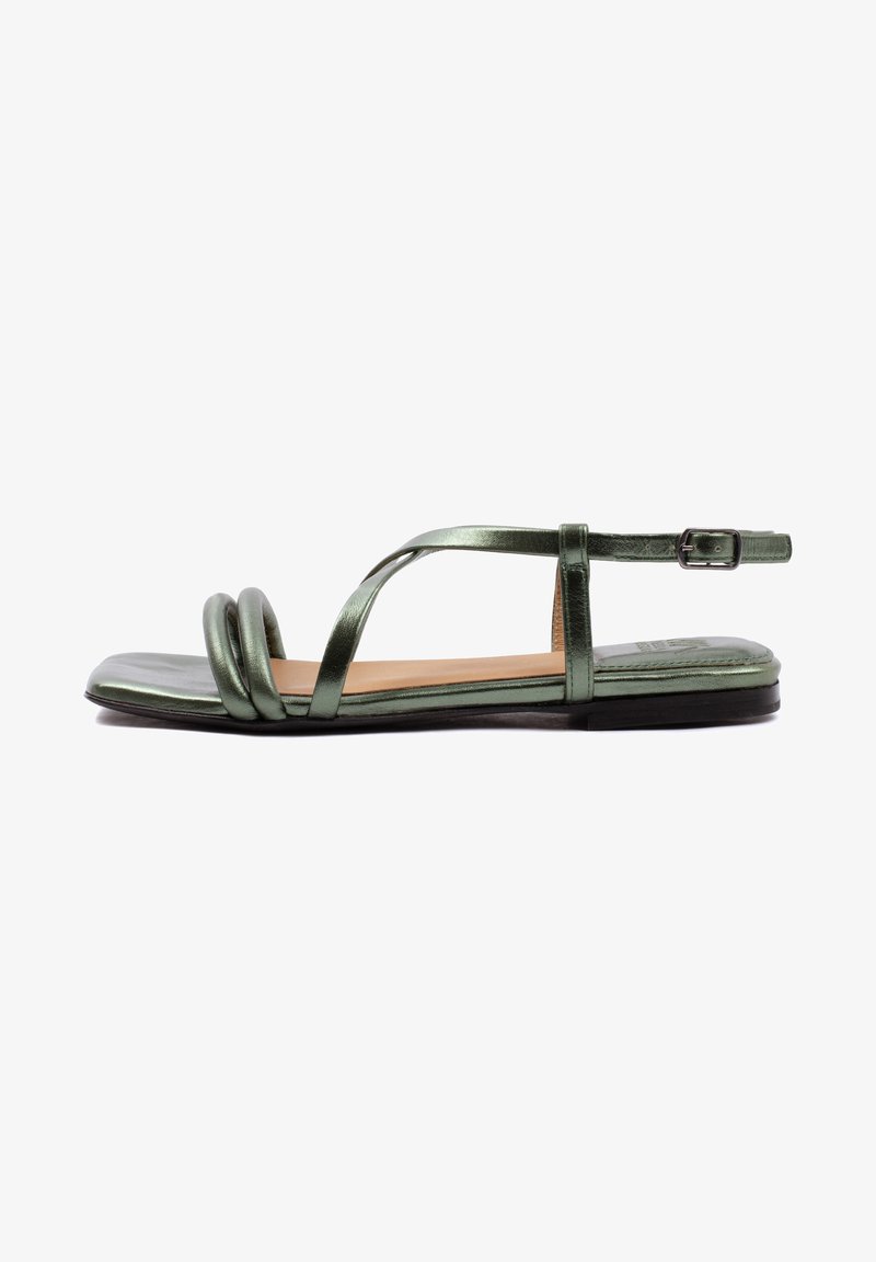 Grüne metallische flache Sandalen mit einer abgerundeten Zehenpartie, die ein Kreuzriemen-Design und zwei gedrehte Riemen vorne haben. Schnallenverschluss am Knöchel.