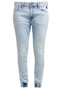 Jeans de mezclilla de color azul claro con corte ajustado, que presentan una cremallera y un botón en la bragueta, dobladillos en los tobillos y bolsillos delanteros y traseros.
