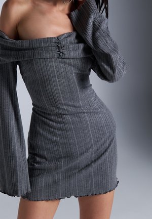 Grau geripptes Kleid mit schulterfreiem Design, langen Ärmeln, Raffung an der Büste und gewelltem Saum. Weicher Stoff und figurbetonte Form.