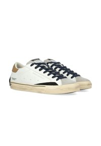 Sneaker in pelle bianca con lacci blu navy, punte in suede grigio e dettagli neri. Presentano un profilo basso e una suola in gomma testurizzata.
