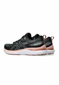Black athletic shoes with a textured mesh upper, white accents, and a pink cushioned sole. Features a pull tab at the heel.