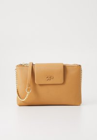 Bolso de cuero sintético en color marrón claro con cierre de cremallera y una solapa magnética. Presenta una correa de cadena dorada y un logo en relieve en la parte frontal.