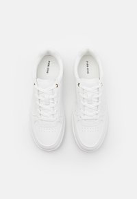 Zapatillas blancas de cuero con un acabado suave, que presentan una puntera redondeada, detalles perforados y cordones planos pasados por ojales dorados.