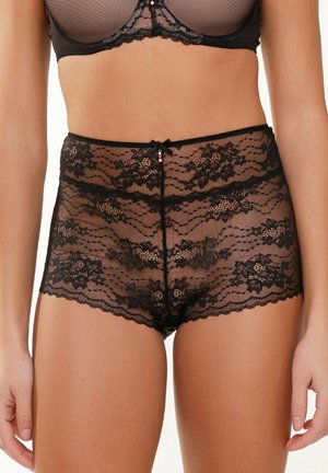 Schwarze Spitzen-Hüfthosen mit floralen Mustern, gewellten Kanten, einer zentralen Schleifenverzierung und einem transparenten Material.