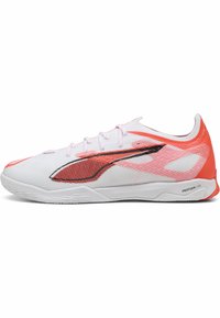 Baskets de sport blanches avec une tige en mesh, présentant des accents rouges et une bande noire. La semelle est plate avec "PROFOAM LITE" imprimé sur le côté.