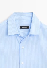 Camicia a righe blu chiaro con colletto classico. Presenta bottoni bianchi e un'etichetta nera con la scritta "Massimo Dutti, Made in Turkey."