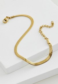 Bracciale in oro con design a forma di serpente, caratterizzato da segmenti lisci e piatti e una chiusura a moschettone. Include una sezione con catena ad anello regolabile.