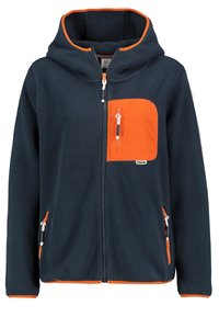 Laivastonsininen fleece-takki, jossa on oranssi hupun reuna, etutasku ja vetoketjusaumakohdat. Sivutaskuissa on oranssit vetoketjut ja pehmeä pinta.